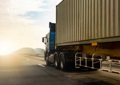Commercial container truck driving on a highway at sunrise, illustrating an on-board weighing equipment project