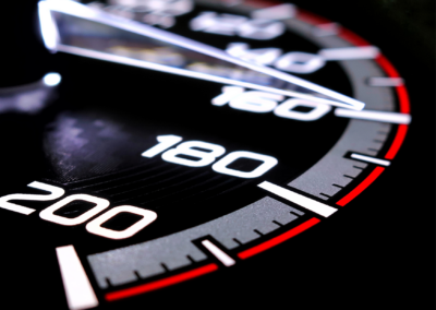 Close-up of a car speedometer needle pointing near 200 km/h, illustrating an extreme performance cars engineering project